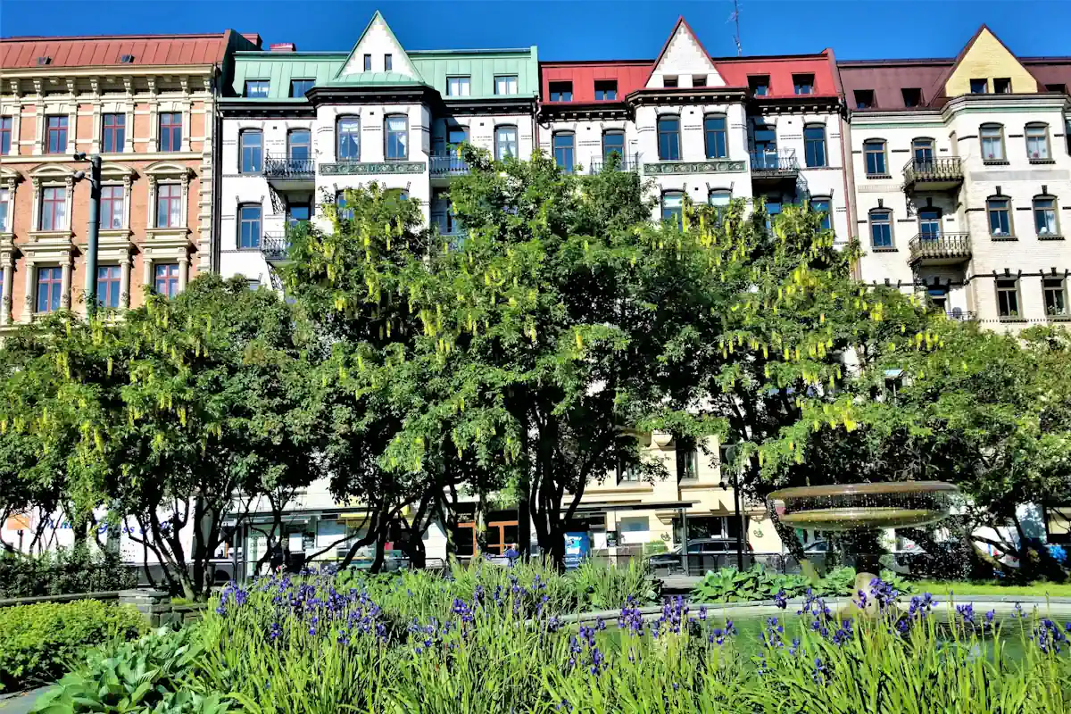 Atmospheric view from Vasaparken in Vasastan, surrounded by trees, open lawns, and everyday city life.
