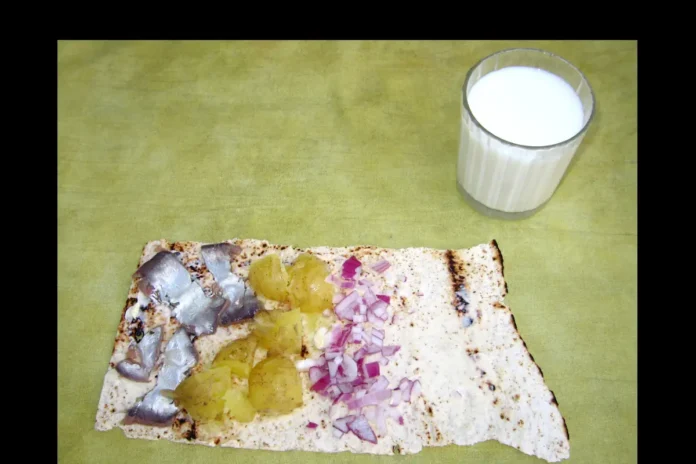 Tunnbröd with three classic ingredients: surströmming, potatoes, and red onion. Photo: Primordial~commonswiki (CC BY-SA 3.0)