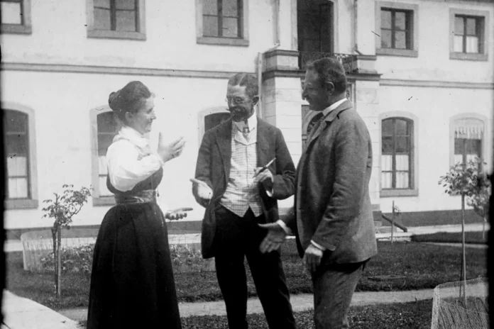Gustaf V conversing with a gentleman and a lady dressed in Tullgarn attire at Tullgarn Palace. Around the year 1900. Photo: Public domain.